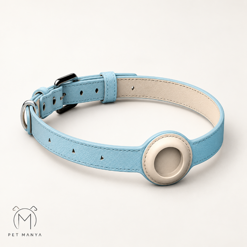 A light blue faux leather dog collar with a cream-colored circular ring on the front, small black triangle accents, and a cream interior lining. The collar is displayed on a clean, off-white background with a 'PET MANYA' logo in the bottom-left corner.