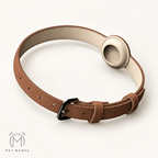 A brown leather pet collar with a cream-colored inner lining, a black metal buckle, and a circular beige insert, displayed on a clean off-white background with the Pet Manya logo in the bottom-left corner.