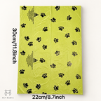 A lime green plastic bag with black paw print patterns, shown flat with dimensions labeled as 30cm/11.8inch tall and 22cm/8.