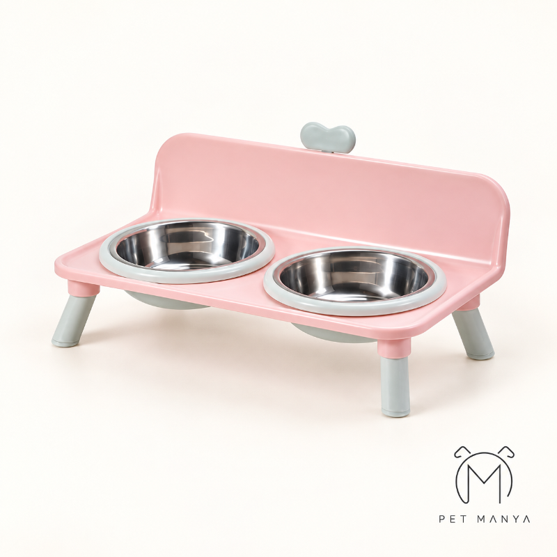 A pink elevated pet feeder and water bowl stand with two stainless steel bowls, shown on a clean off-white background. The brand logo 'PET MANYA' is visible in the bottom right corner.