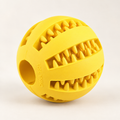 A bright yellow silicone dog toy ball with a textured, tooth-like pattern on its surface, photographed on a clean white background.