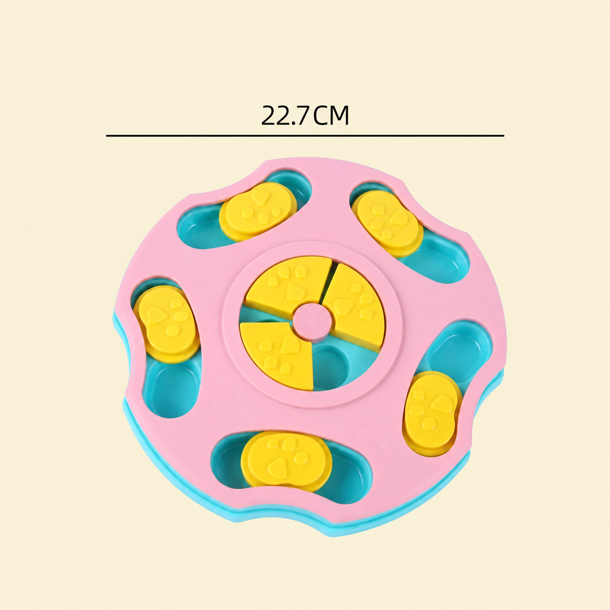 A pink and blue circular pet toy with yellow puzzle pieces, shown on a light beige background with a dimension line indicating 22.7CM across the top.