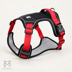 A red and black dog harness with gray mesh padding, shown on a light beige background. The brand logo 'Pet Manya' is visible in the bottom-left corner.