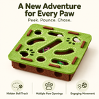 A square felt pet toy with a green top and brown base, featuring paw-print and track-shaped cutouts, small brown chew pieces, and colorful balls visible inside. Large text at the top reads 'A New Adventure for Every Paw' and three feature icons at the bottom describe hidden ball track, multiple paw openings, and engaging movement.