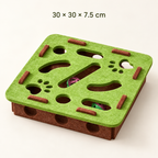 A square felt cat toy with a green top and brown base, featuring cutout pathways, small stick holders, and colorful balls visible inside. Text at the top reads '30 x 30 x 7.