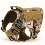 A tactical dog harness in a camouflage pattern of tan, brown, and green, featuring a padded chest panel with MOLLE webbing and adjustable plastic buckles.