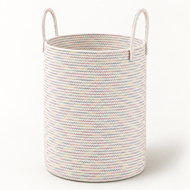 A cylindrical woven storage basket with two loop handles, featuring a multicolor chevron stripe pattern on a white base, set against a plain white background.